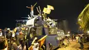 Para pengunjuk rasa berdiri di atas truk water canon polisi yang dirusak dan meneriakkan slogan-slogan di pintu masuk kediaman resmi presiden di Kolombo, Sri Lanka, 9 Juli 2022. Banyak orang di negara kepulauan berpenduduk 22 juta orang itu menyalahkan kemerosotan negara itu pada Rajapaksa. (AP Photo/Eranga Jayawardena)