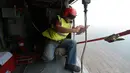 Seorang awak helikopter Kamov yang dioperasikan Basarnas mengambil foto selama operasi pemboman air di Pelalawan, Riau, Kamis (17/9/2015). Asap dari kebakaran hutan ini mengakibatkan aktivitas warga Riau dan sekitarnya terganggu (AFP Photo/Adek Berry)