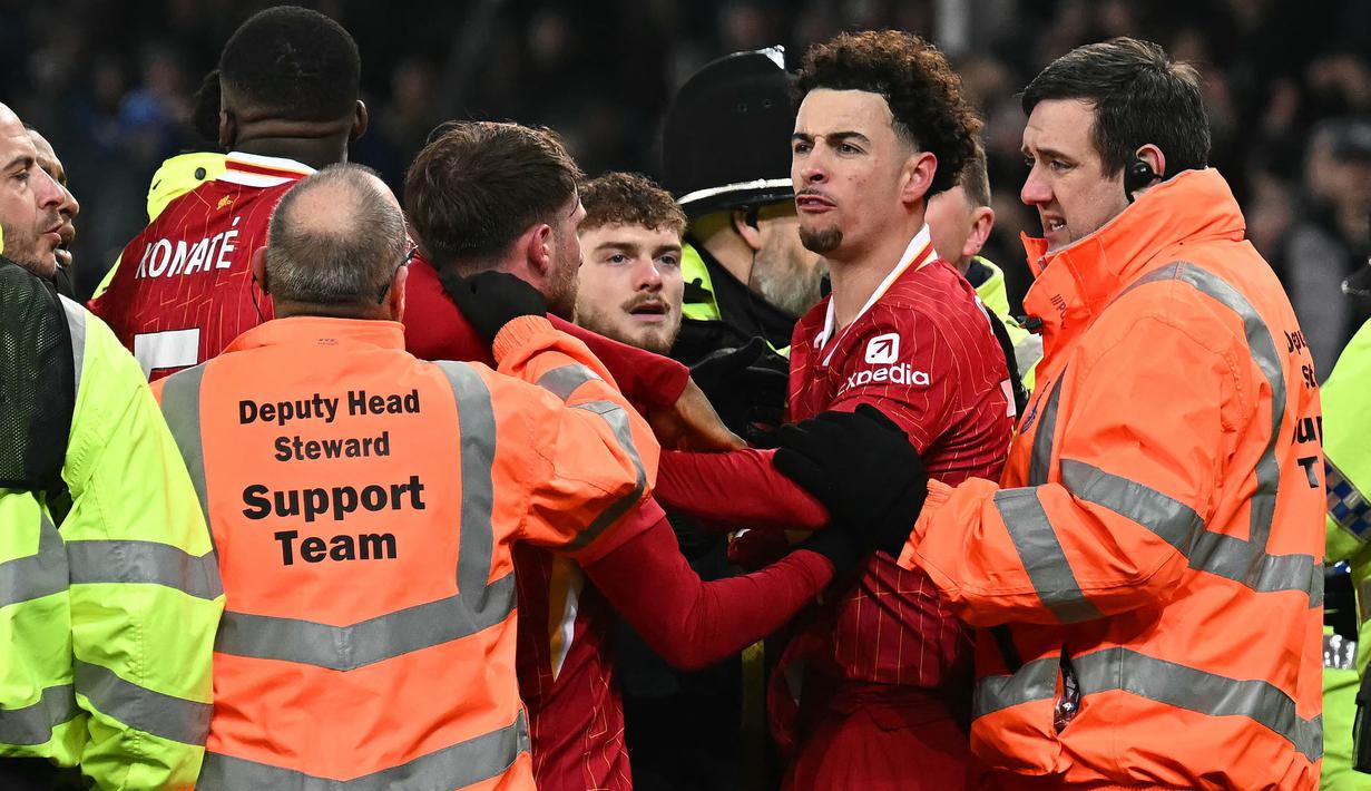 Pemain Liverpool, Curtis Jones berusaha dipisahkan saat terlibat perseteruan dengan pemain Everton, Abdoulaye Doucoure setelah laga lanjutan Liga Inggris 2024/2025 di Goodison Park, Liverpool, Inggris, Rabu (13/02/2025) WIB. (AFP/Paul Ellis)
