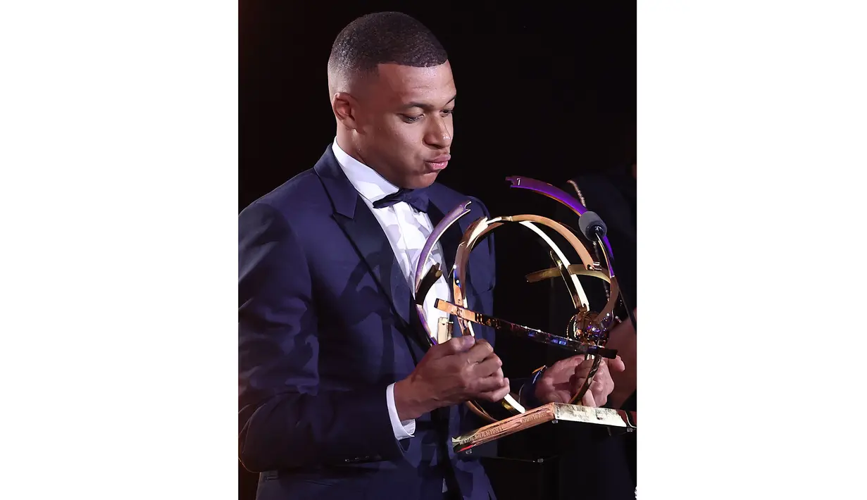 Ekspresi pemain PSG, Kylian Mbappe saat mendapatkan penghargaan pemain terbaik Ligue1 Prancis pada acara yang berlangsung di Paris, Prancis, Senin (13/04/2024) waktu setempat. (AFP/Franck Fife)