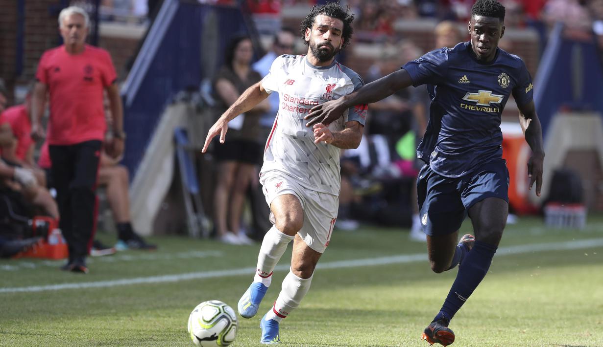 Penyerang Liverpool, Mohamed Salah, berebut bola dengan pemain Manchester United, Axel Tuanzebe, pada laga ICC 2018 di Stadion Ann Arbor, Michigan, Minggu (29/7/2018). Liverpool menang 4-1 atas Manchester United. (AP/Carlos Osorio)