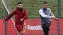 Bek MU, Lisandro Martinez (kiri), melakukan gerakan ringan didampingi asisten pelatih saat sesi latihan yang berlangsung di Carrington, Manchester, Selasa (12/12/2023) dini hari WIB. (AFP/Darren Staples)