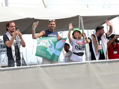 Aktivis iklim Swedia, Greta Thunberg (ketiga kiri) bersama sejumlah aktivis melambaikan tangan saat kapal mereka, yang merupakan bagian dari armada sipil yang bertujuan untuk memecahkan blokade Israel di Jalur Gaza, berangkat dari pelabuhan Barcelona pada 31 Agustus 2025. (Lluis GENE/AFP)
