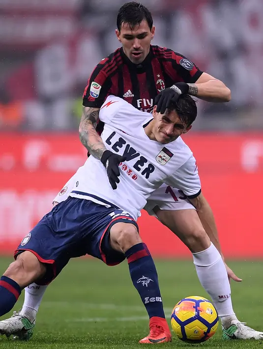 Bek AC Milan, Alessio Romagnoli berusaha merebut bola dari pemain Crotone, Ante Budimir saat bertanding pada lanjutan Liga Serie A Italia di San Siro, Milan (6/1). Milan menang tipis 1-0 atas Crotone. (AFP Photo/Marco Bertorello)