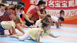 Para orang tua dan bayi mereka ikut dalam lomba merangkak yang digelar di sebuah pusat perbelanjaan di Distrik Daxing, Beijing, ibu kota China (13/9/2020). (Xinhua/Li Xin)