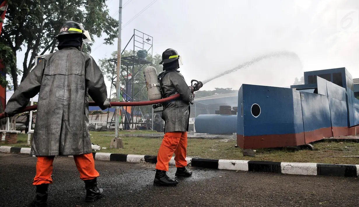 Pasukan pemadam Kesatuan Penjagaan Laut dan Pantai (KPLP) melakukan simulasi menjinakkan kebakaran kapal saat peringatan HUT ke-31 Pangkalan PLP di Lapangan Pangkalan PLP Kelas I Tanjung Priok, Jakarta, Selasa (26/2/2019). (Merdeka.com/Iqbal S. Nugroho)