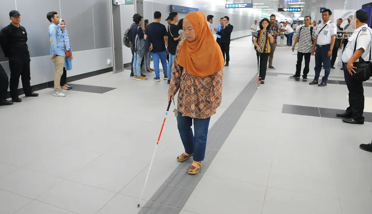 Penyandang disabilitas berjalan di guiding block usai menaiki kereta MRT di Jakarta, Kamis (21/3). Dalam kesempatan tersebut mereka dapat menikmati fasilitas yang disediakan untuk disabilitas. (Liputan6.com/Angga Yuniar)