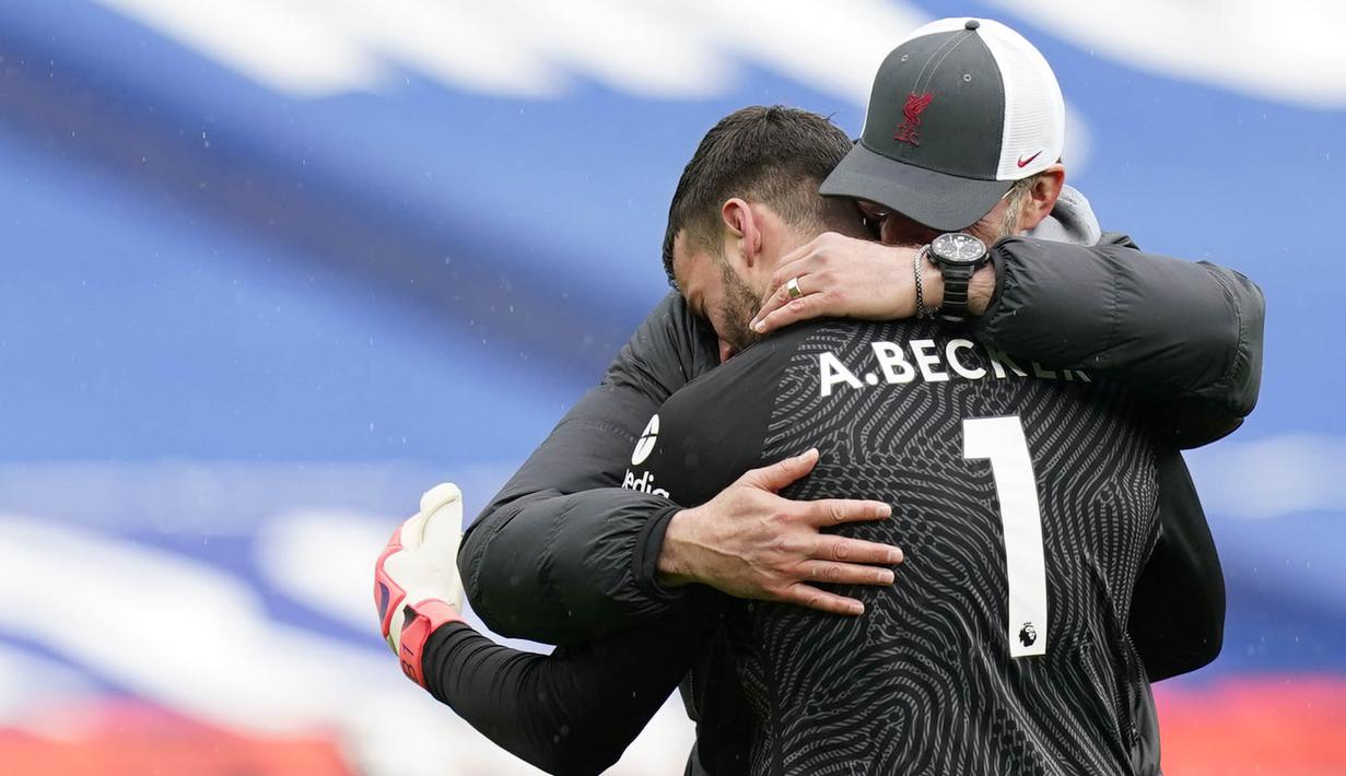 Kiper Liverpool, Alisson Becker, dipeluk oleh Jurgen Klopp usai laga melawan West Bromwich Albion pada laga Liga Inggris di Stadion the Hawthorns, Minggu (16/5/2021). Liverpool menang dengan skor 2-1. (Tim Keeton/Pool via AP)