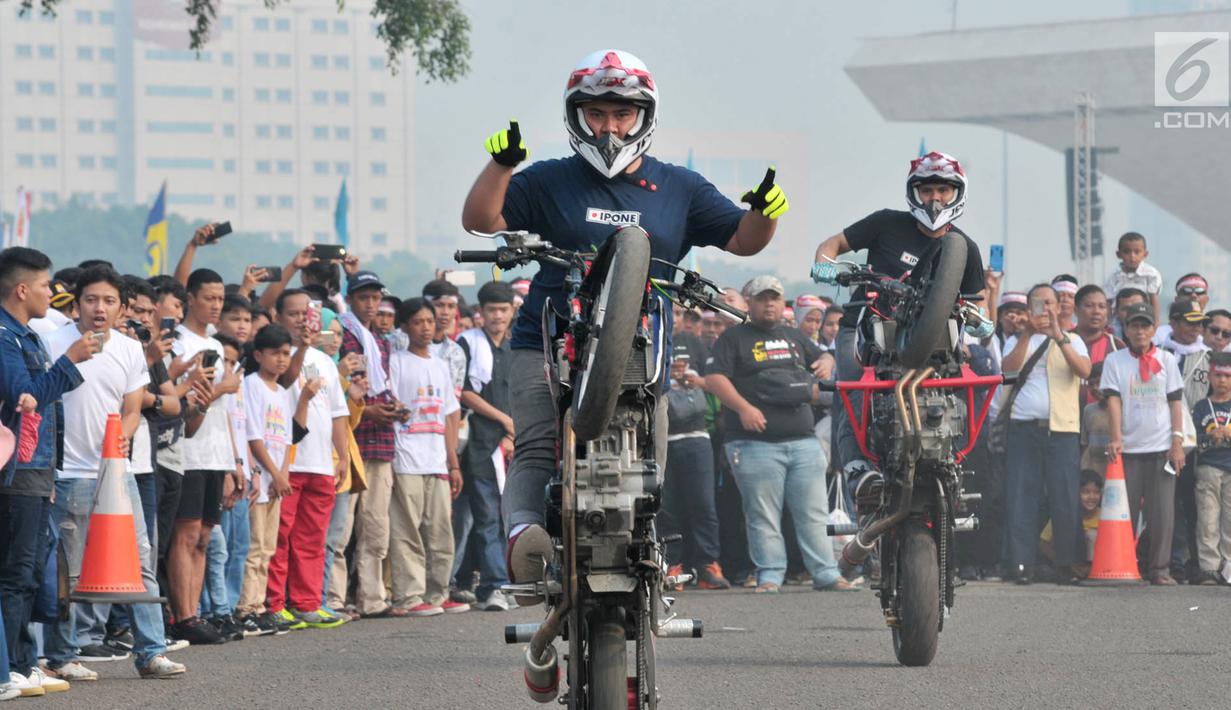 Freestyler melakukan atraksi freestyle sepeda motor saat memeriahkan Festival Damai Millenial Road Safety di Monas, Jakarta, Minggu (23/6/2019). Festival ini menyosialisasikan disiplin berlalu lintas serta merajut persatuan dan kesatuan, khususnya generasi millienial. (merdeka.com/Iqbal Nugroho)