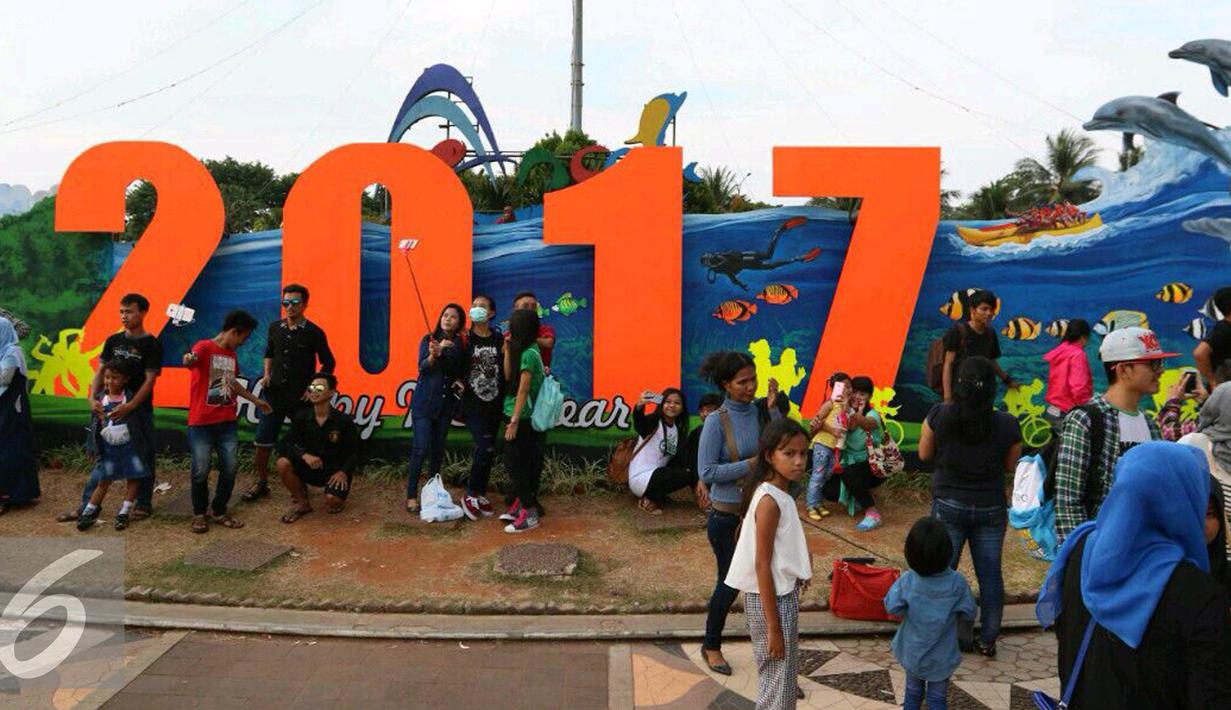Sejumlah pengunjung berfoto di kawasan pantai Ancol, Jakarta, Sabtu (31/12). Kawasan Ancol menjadi tempat favorit masyarakat untuk menikmati pergantian malam tahun baru 2016 menuju 2017 di Jakarta. (Liputan6.com/Angga Yuniar)