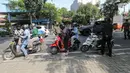 Petugas memeriksa identitas pengendara bermotor pada hari pertama Pemberlakuan Pembatasan Sosial Berskala Besar (PSBB) di jalur check point Jalan Ir. H Juanda, Ciputat, Tangerang Selatan, Sabtu (18/4/2020). Selama PSBB pengendara wajib kenakan masker dan sarung tangan. (Liputan6.com/Fery Pradolo)