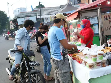 Warga melakukan aktivitas jual beli makanan untuk berbuka puasa (takjil) di kawasan Jalan Panjang, Jakarta, Selasa (5/5/2020). Pandemi virus COVID-19 dan pelaksanaan Pembatasan Sosial Berskala Besar (PSBB) berimbas pada sepinya pembeli takjil di kawasan tersebut. (Liputan6.com/Helmi Fithriansyah)