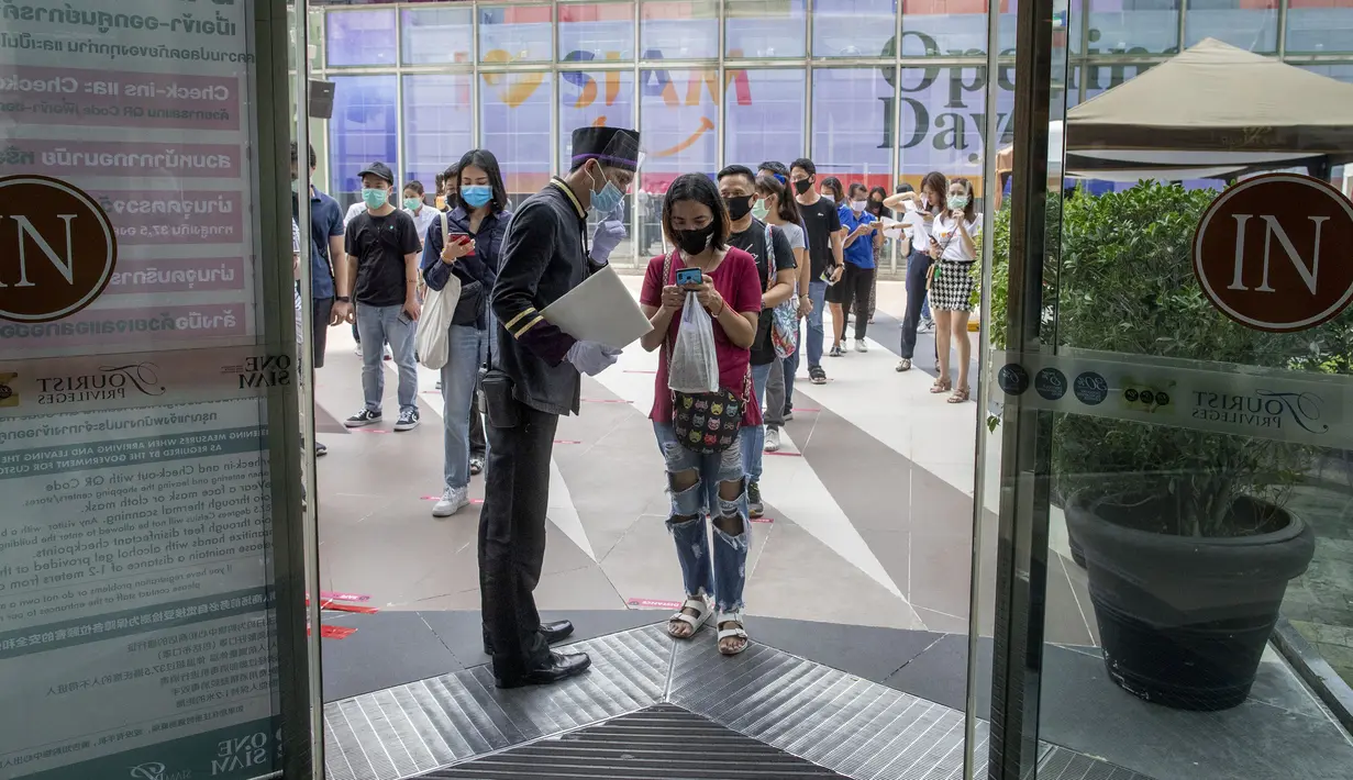 Penjaga mengecek pengunjung yang akan masuk mal mewah Siam Paragon di Bangkok, Thailand, Minggu (17/5/2020). Thailand mengizinkan toko serba ada, pusat perbelanjaan, dan bisnis lainnya kembali dibuka untuk menghidupkan kembali ekonomi yang rusak akibat pandemi COVID-19. (AP Photo/Gemunu Amarasinghe)