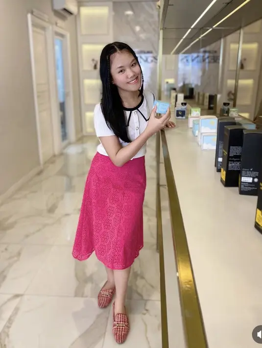 Ia juga tampil dengan atasan putih berkancing dipadukan midi skirt fushchia dan sandal slopnya. . @kiranavelovoiceee