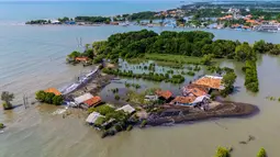 Sejumlah wilayah pesisir utara Jawa Tengah terancam tenggelam. Tampak dalam foto yang diambil pada 29 Juli 2025 menunjukkan pemandangan udara rumah-rumah yang terbengkalai dan sebagian terendam air, yang hilang akibat kenaikan pasang surut akibat perubahan iklim, di Desa Semonet, Pekalongan, Jawa Tengah. (BAY ISMOYO/AFP)