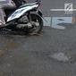 Pengendara mobil dan sepeda motor menghindari jalan yang ruas saat melintasi ruas Jalan Lapangan Ros, Tebet, Jakarta, Sabtu (11/5/2019). Jalan-jalan berlubang yang terisi air tersebut dapat mengakibatkan kecelakaan bagi pengendara kendaraan bermotor. (merdeka.com/Imam Buhori)
