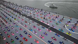 Personel pertahanan India melakukan yoga di dek kapal induk Angkatan Laut India Viraat untuk memperingati Hari Yoga Internasional yang jatuh pada 21 Juni di Mumbai, India, Kamis (21/6). (AP Photo/Rafiq Maqbool)
