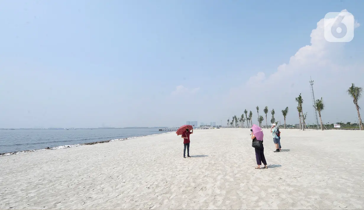 Warga berfoto di hamparan pasir putih White Sand Beach, Pantai Indah Kapuk (PIK) 2, Jakarta Utara, Sabtu (5/6/2021). Hamparan pasir putih buatan sepanjang sekitar 4 Km menjadi salah satu destinasi warga Jabotabek untuk berlibur. (merdeka.com/Arie Basuki)