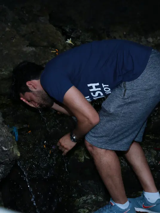 Berkunjung ke Tanah Lot, pria tampan ini pun minum air suci yang berada di bawah pura Sad Kahyangan yang berada di atas karang besar. (Deki Prayoga/Bintang.com)