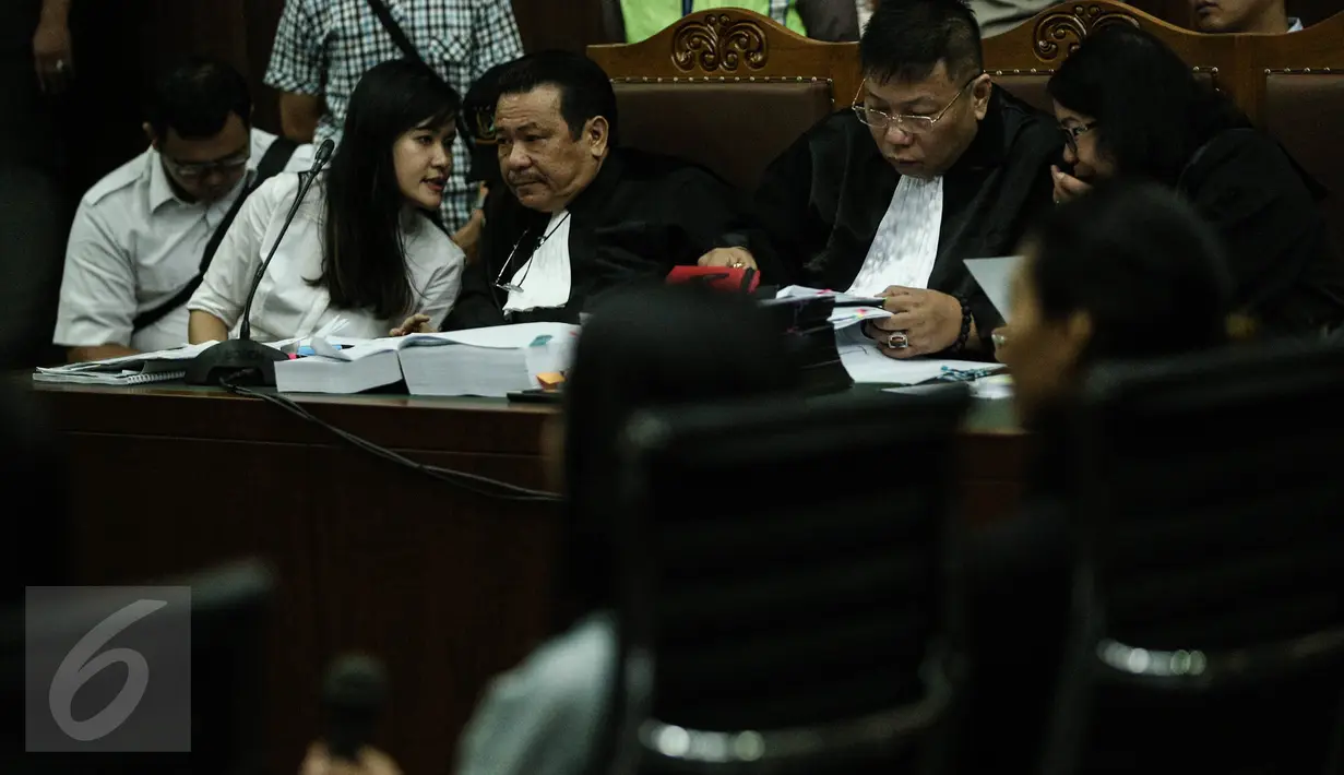 Tersangka pembunuhan Wayan Mirna Salihin, Jessica Kumala Wongso berdiskusi dengan kuasa hukum disela sidang lanjutan di PN Jakarta Pusat, Rabu (13/7). Sidang mendengarkan kesaksian Hanie, teman minum kopi korban dan tersangka  (Liputan6.com/Faizal Fanani)
