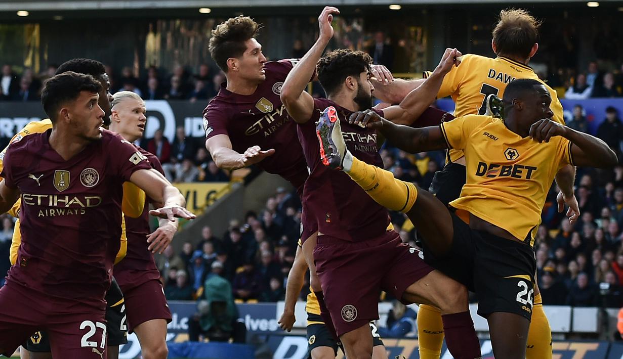 John Stones (tengah) menanduk bola di tengah kotak penalti yang berhasil menjadi gol pada laga Manchester City melawan Wolverhampton di laga pekan ke delapan Premier League 2024/2025 di Molineux, Minggu (20/10/2024) malam WIB.