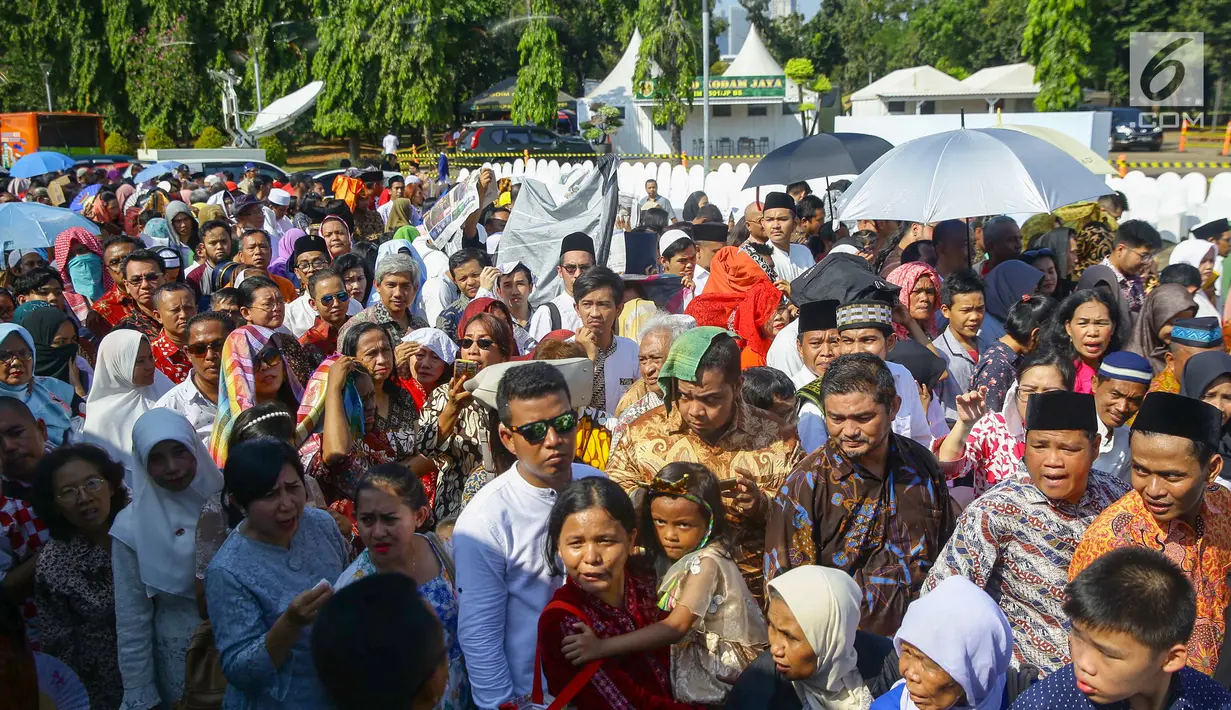 Warga mengantre di kawasan Silang Monas, untuk mengikuti Open House Jokowi di Istana Kepresidenan, Jakarta Rabu (5/6/2019). Warga mulai rela antre setelah Salat Id meski Istana baru dibuka pada pukul 10.00 WIB. (Liputan6.com/HO/Grandy)
