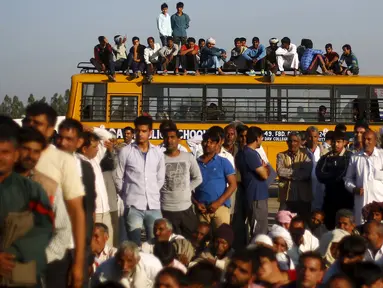 Sejumlah orang duduk di bus sekolah saat memblokir jalan dalam demonstrasi di negara bagian Haryana ke New Delhi, India,Minggu (21/2). Demonstrasi dan aksi kekerasan akibat kelangkaan air di wilayah tersebut menewaskan 10 orang. (REUTERS/Adnan Abidi)