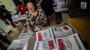 Seorang ibu menyelesaikan pelipatan surat suara Pemilihan Umum 2019 di gudang logistik KPU Jakarta Pusat, Selasa (19/2). Tugas pertama para pekerja ialah menyortir surat suara antara surat suara yang cacat dan yang tidak cacat (Liputan6.com/Faizal Fanani)