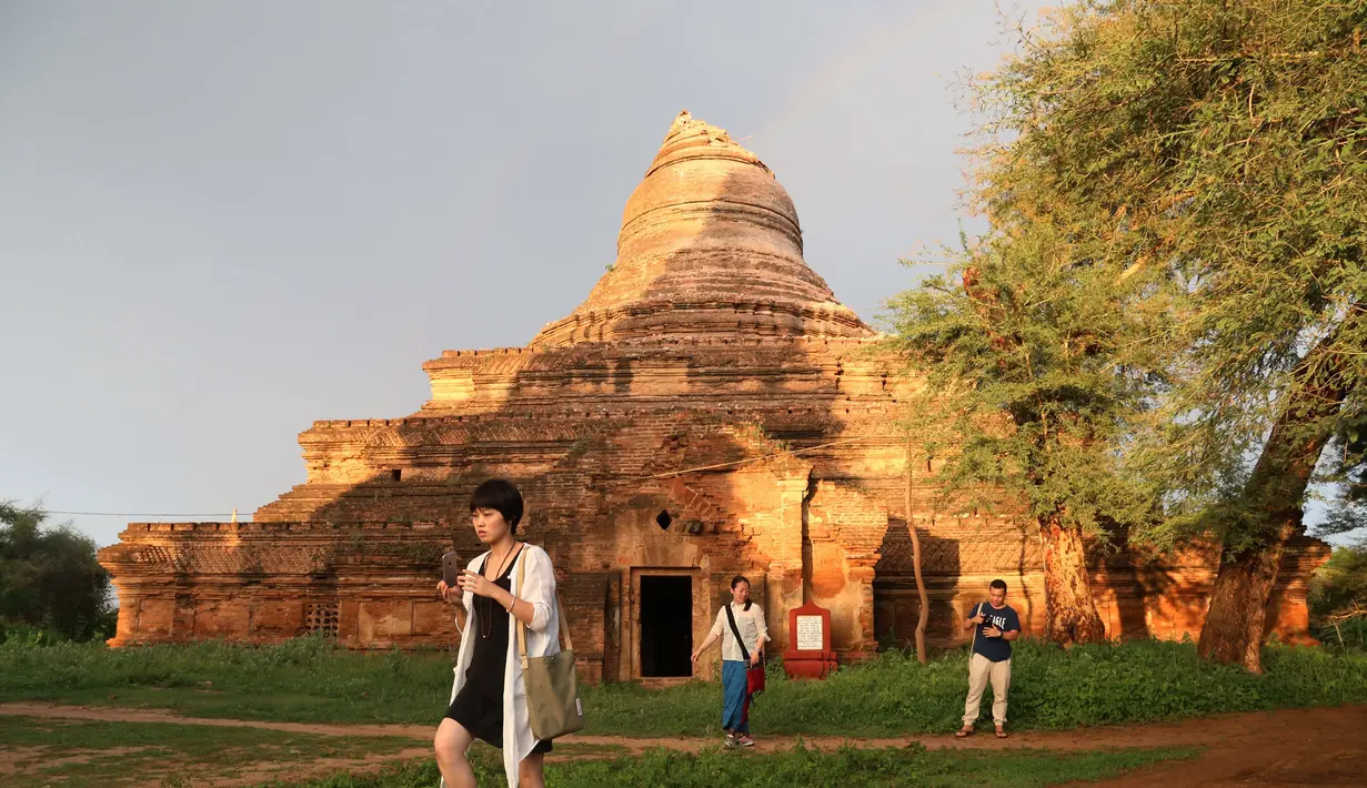 Turis mengambil gambar dari dampak gempa di salah satu Pagoda di Bagan, Myanmar, Rabu (24/8). Kerusakan berat terjadi di Bagan yang merupakan situs arkeologi paling terkenal dan berjarak sekira 30 km dari titik pusat gempa. (AFP PHOTO/Soe MOE AUNG)