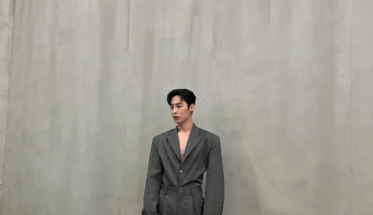 Lee Jae Wook mengenakan oversized suit berwarna abu-abu tua. Dia melengkapi penampilannya dengan tas berwarna hitam. (Foto: Instagram/ jxxvvxxk)