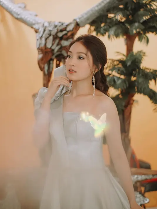 Gaun abu-abu one shoulder dengan detail pita besar di bagian dada (Instagram @natashawilona12)