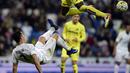 Cristiano Ronaldo melakukan tendangan salto saat dihadang pemain Villarreal, Eric Bally, pada lanjutan La Liga Spanyol di Stadion Santiago Bernabeu, Madrid, Rabu (20/4/2016) atau Kamis dini hari WIB. (AFP/Javier Soriano)
