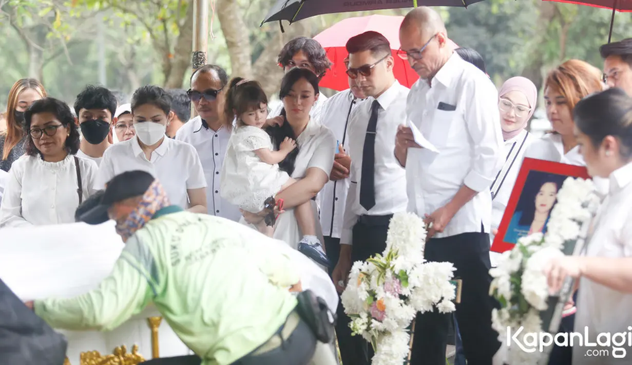 Ibunda Jonas menghembuskan napas terakhirnya di RS St Carolus, Senen, Jakarta Pusat setelah berjuang melawan kanker dekat salurah kemih sejak tahun 2008 silam.  Asmirandah mengendong putrinya menyaksikan prosesi pemakaman ibu mertuanya.  [Foto: Bayu Herdianto/KapanLagi.com]