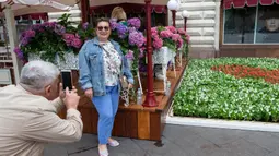 Orang-orang mengambil foto dalam festival bunga tahunan di pusat perbelanjaan GUM di dekat Lapangan Merah, pusat Kota Moskow, Rusia, pada 15 Juli 2020. Sekitar 200.000 bunga ditanam di dalam dan luar pusat perbelanjaan tersebut pada tahun ini. (Xinhua/Alexander Zemlianichenko Jr)