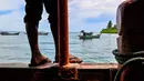 Penyelesaian didasarkan pada pertimbangan data historis, kultural, dan hukum, termasuk merujuk pada Undang-Undang Nomor 24 Tahun 1956 tentang Pembentukan Daerah Otonom Provinsi Aceh. Tampak dalam foto, seorang pria memandang ke arah perahu nelayan yang berlabuh di lepas Pulau Panjang, yang pernah menjadi objek sengketa batas pulau antara Aceh dan Sumatera Utara, di Singkil, Provinsi Aceh Selatan, pada Rabu 12 November 2025. (CHAIDEER MAHYUDDIN/AFP)