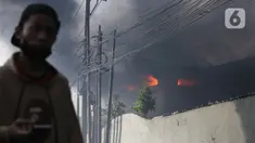 Asap hitam membumbung dari atas Gudang JNE Express yang terbakar di Jalan Pekapuran Raya, Depok, pada Senin (12/9/2022). JNE menjamin barang milik konsumen yang rusak  dalam peristiwa kebakaran gudang di Depok akan diganti. (Liputan6.com/Herman Zakharia)