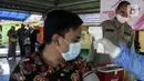 Warga menjalani pemeriksaan kesehatan saat mengikuti vaksinasi booster COVID-19 di Taman Pemuda Pratama, Depok, Jawa Barat, Kamis (7/4/2022). Presiden Joko Widodo telah mempersilakan masyarakat untuk mudik pada Lebaran 2022. (Liputan6.com/Johan Tallo)