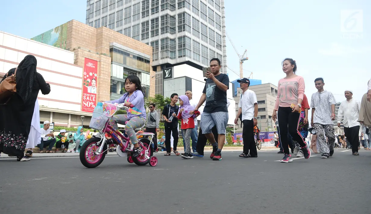 Seorang anak perempuan bersepeda saat Car Free Day (CFD) di kawasan Jakarta, Minggu (2/12). Warga tetap memadati area Car Free Day  dari Bundaran HI-Sudirman meskipun ada aksi Reuni 212. (Liputan6.com/Angga Yuniar)