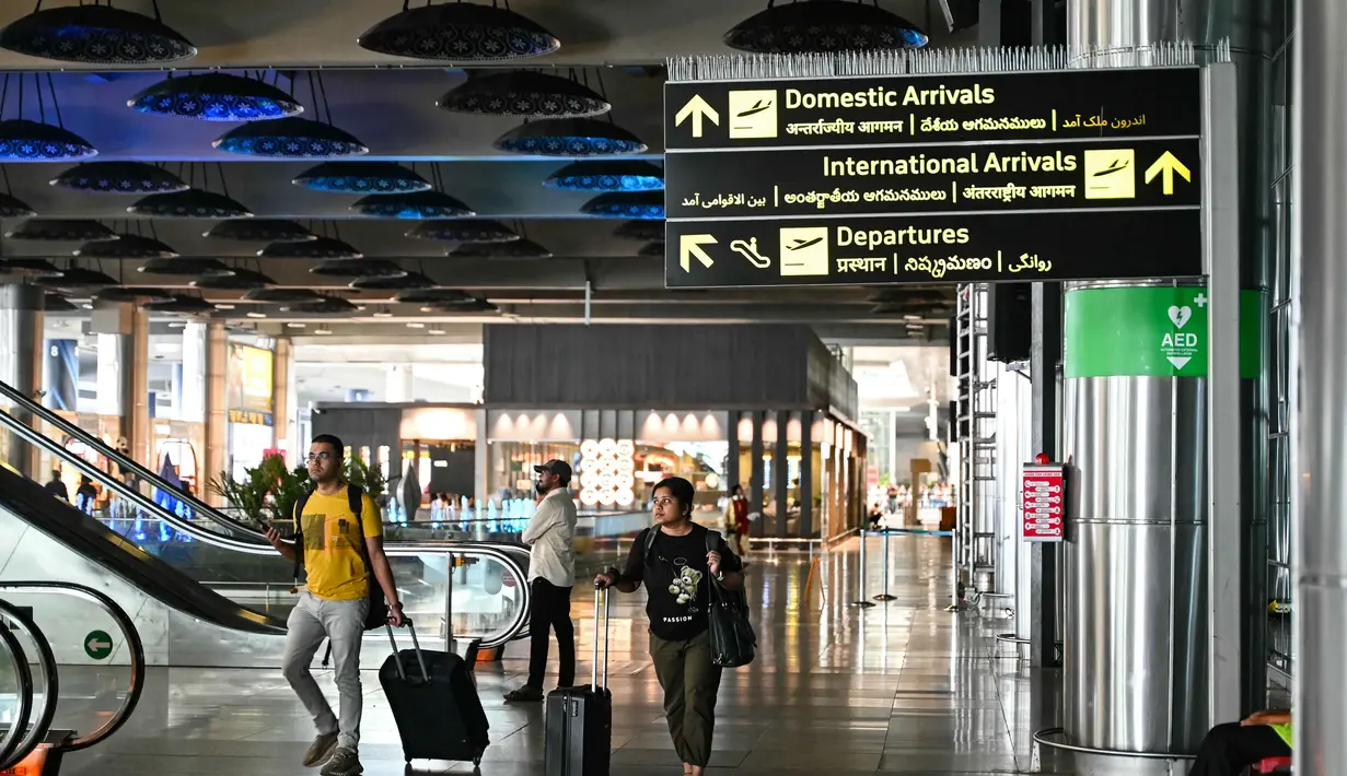 Sejumlah otoritas Penerbangan Sipil Umum, termasuk Uni Emirat Arab (UEA) atau General Civil Aviation Authority (GCAA) juga telah mengumumkan penutupan sementara sebagian wilayah udara, seiring meningkatnya aksi militer di Timur Tengah. Tampak dalam foto, para penumpang membawa tas mereka di terminal kedatangan Bandara Internasional Rajiv Gandhi di Hyderabad pada Minggu 1 Maret 2026 ketika dua maskapai penerbangan swasta terbesar India, IndiGo dan Air India, menangguhkan penerbangan ke semua tujuan di Timur Tengah. (Noah SEELAM/AFP)