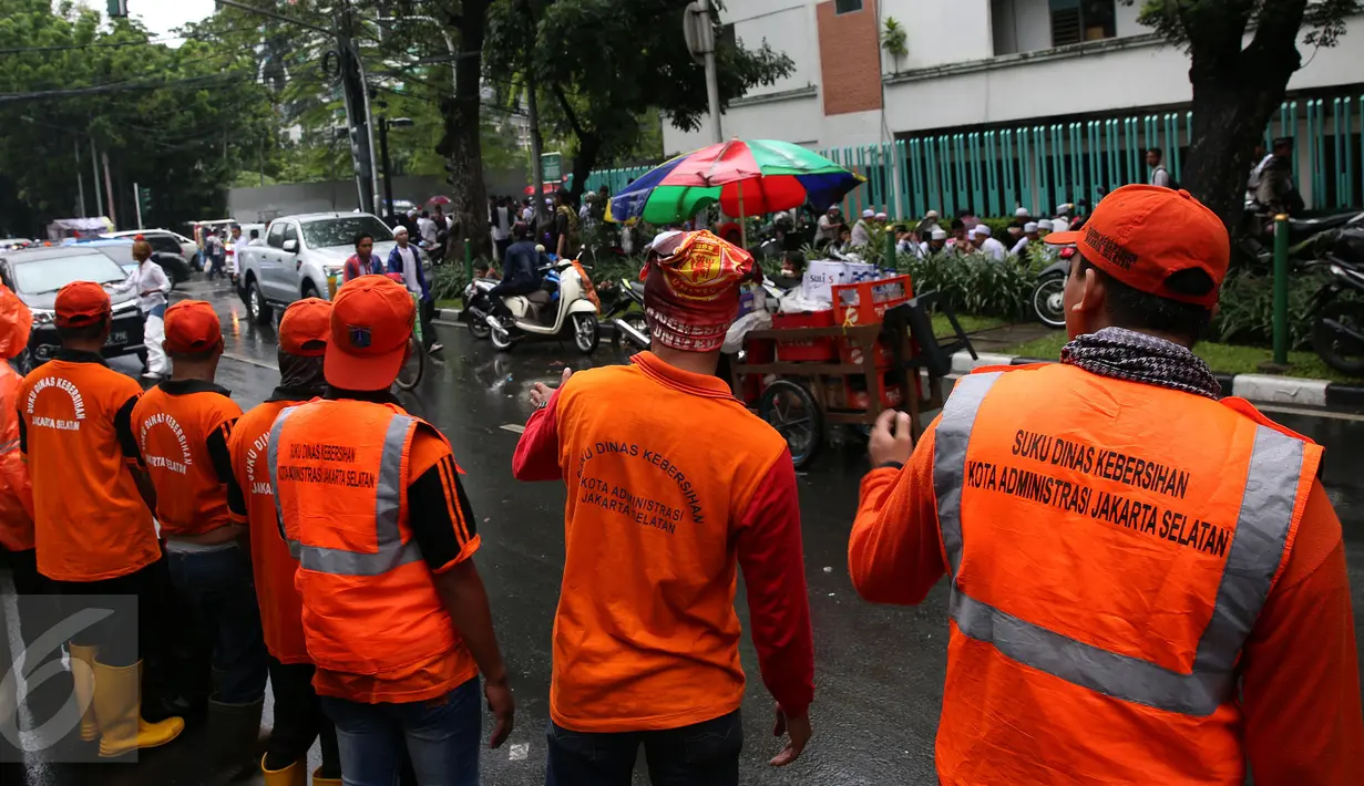 Pasukan oranye (petugas kebersihan) disiagakan membersihkan kawasan Monas, Jakarta, saat berlangsungnya aksi damai 2 Desember, Jumat (2/12). Pasukan oranye dibekali kantong plastik besar untuk memungut sampah yang berserakan. (Liputan6.com/Johan Tallo)