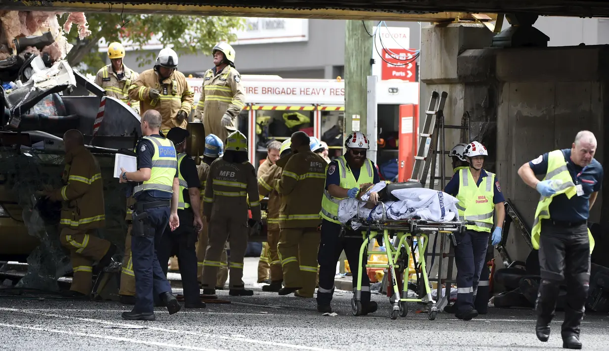 Petugas mengevakuasi penumpang dari dalam bus yang menabrak kolong jembatan kereta di Montague, South Melbourne, Australia (22/2). Belum diketahui penyebab tertabraknya bus yang mengangkut 19 orang ini. (REUTERS/Mal Fairclough)