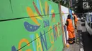 Petugas PPSU Kelurahan Kuningan Timur membuat lukisan mural bertema Asian Games 2018 di Jalan Perintis, Jakarta, Kamis (5/7). Mural tersebut untuk menyambut dan memeriahkan pelaksanaan Asian Games 2018. (Liputan6.com/Arya Manggala)