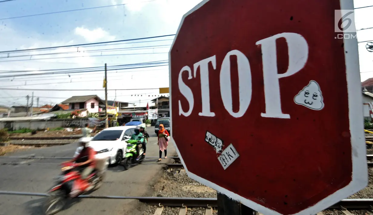 Sejumlah kendaraan melintasi perlintasan kereta api Nomor 52 di Pisangan Lama, Jakarta, Kamis (11/4). Pintu perlintasan ini dan JPL 66 di Jalan Stasiun Cakung akan ditutup permanen saat diberlakukannya Double Double Track (DDT) lintas Manggarai-Cikarang. (merdeka.com/Iqbal S. Nugroho)