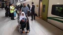 Para penumpang berjalan di peron ketika kereta api kecepatan tinggi Haramain resmi beroperasi di stasiun kereta Makkah, Kamis (11/10). Kereta akan berhenti di beberapa titik termasuk Jeddah dan Kota Ekonomi King Abdullah (KAEC). (BANDAR ALDANDANI/AFP)