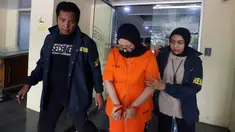 Ayu Puspita, pemilik Wedding Organizer by Ayu Puspita (tengah), digelandang petugas dari unit Kriminal Umum Polda Metro Jaya usai rilis di Gedung Ditreskrimum Polda Metro Jaya, Sabtu (13/12/2025). Polda Metro Jaya merilis kasus penipuan yang dilakukan Ayu Puspita, pemilik Wedding Organizer by Ayu Puspita. (Kapanlagi.com/Budy Santoso)
