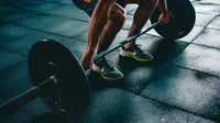 Foto: Lelaki sedang latihan angkat beban di gym demi membentuk massa otot (unsplash/VictorFreitas)