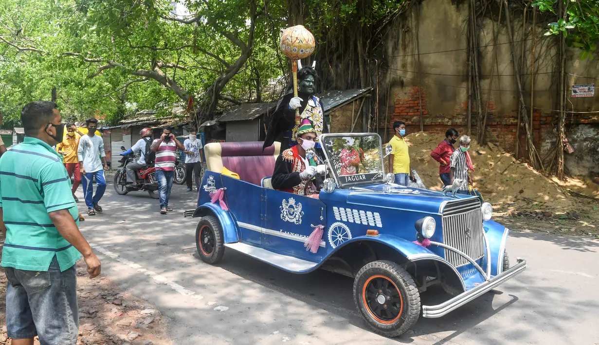 Aksi pria berkostum dewa kematian Yamaraj saat keliling kota menggunakan mobil klasik memberikan imbauan kepada warga soal bahaya wabah Covid-19  di tengah lockdown di Kota Kolkata, India (24/4/2020).  (AFP/Dibyangshu Sarkar)