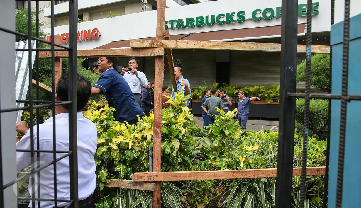 Seng-seng yang menutupi bagian depan gerai Starbucks, Jalan MH Thamrin, Jakarta, mulai dibongkar petugas, Jumat (15/1). Pasca-ledakan, pihak pengelola Menara Cakrawala memagari dengan seng, di sekeliling gedung. (Liputan6.com/Faizal Fanani)