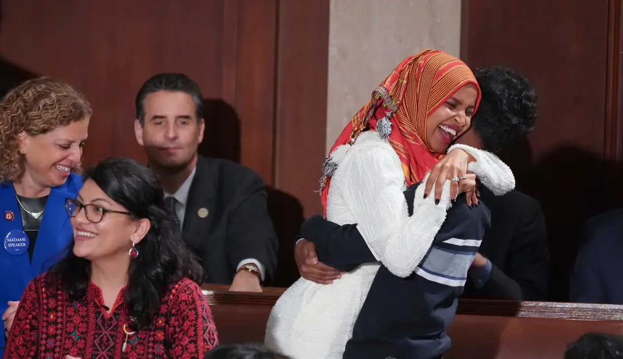 Senator Amerika Serikat (AS) Ilhan Omar merangkul putra sulungnya usai mengikuti pelantikan di Gedung Kongres AS, Capitol, Washington, Kamis (3/1). Omar mengenakan hijab saat pelantikan dirinya sebagai Anggota Senat AS. (Glen Stubbe/Star Tribune via AP)