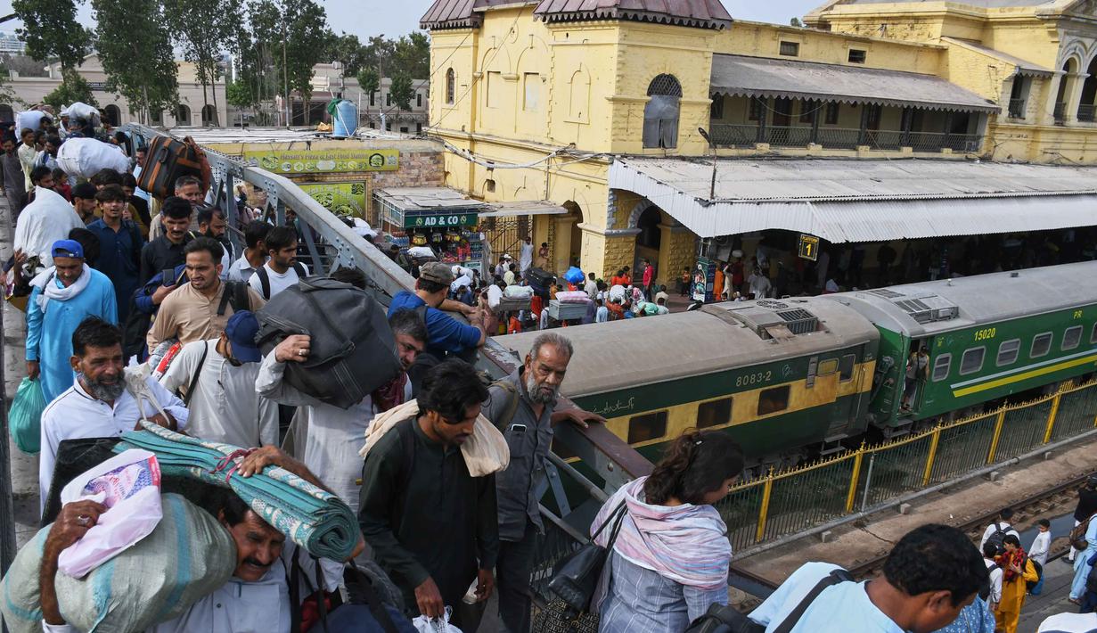 Jutaan perantau dari kota besar seperti Karachi, Lahore, dan Islamabad kembali ke kampung halaman untuk bersilaturahmi saat Hari Raya Idul Fitri. Tampak dalam foto, orang-orang tiba di stasiun kereta api di Karachi, Pakistan, Selasa 17 Maret 2026, untuk menaiki kereta untuk pulang ke kampung halaman untuk Hari Raya Idul Fitri yang akan datang, sekaligus menandai berakhirnya bulan suci Ramadan. (AP Photo/Ali Raza)